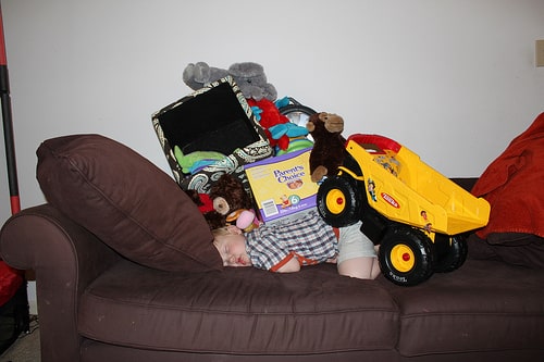 kid asleep under toys