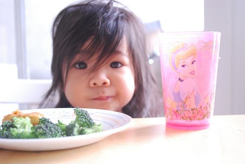 kid with veggies and princess cup