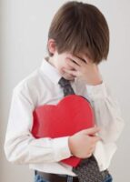 Young Boy Embarrassed Holding Heart Shaped Box