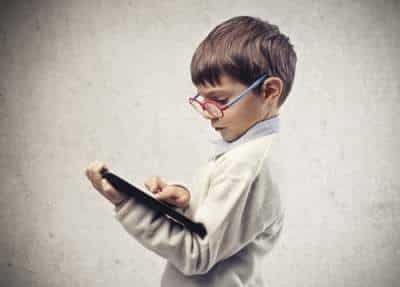 little boy with glasses and tablet