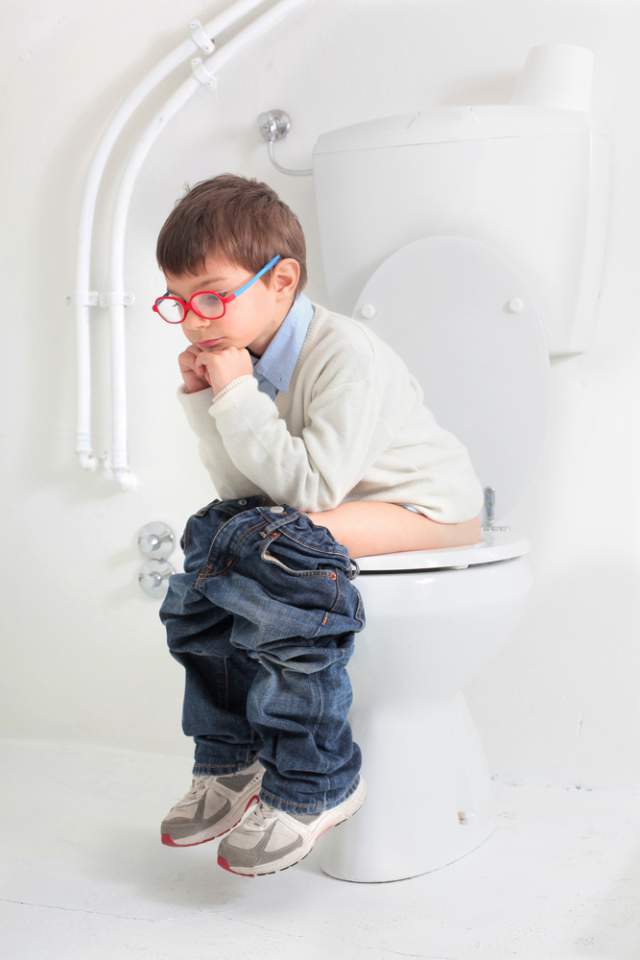 boy sitting on toilet