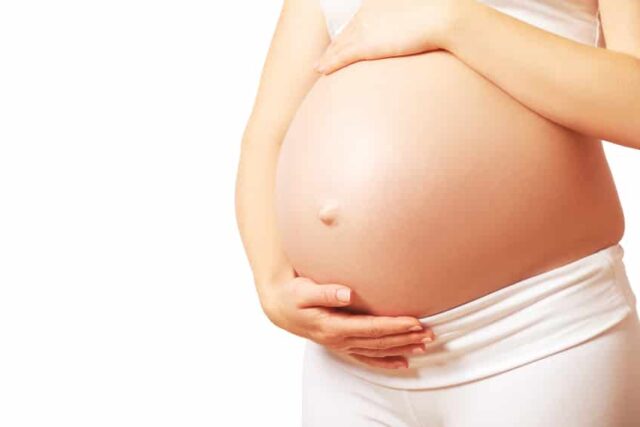belly tummy of  pregnant woman on white background