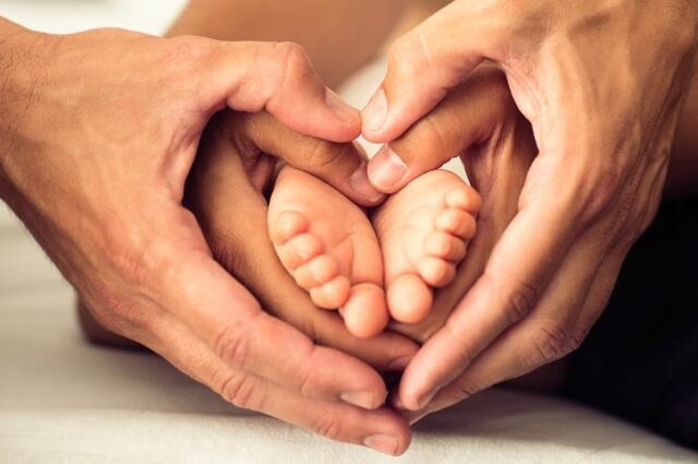 Newborn baby feet in the mother and father hands