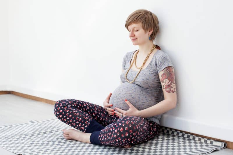 pregnant woman on floor holding belly